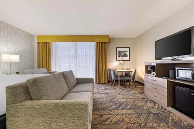 a hotel room with a bed and a couch and a television at Best Western Plus Bayside Inn in San Diego