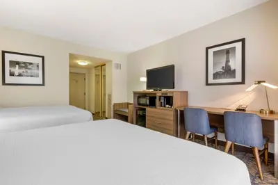 a hotel room with two beds and a desk and a tv at Best Western Plus Bayside Inn in San Diego
