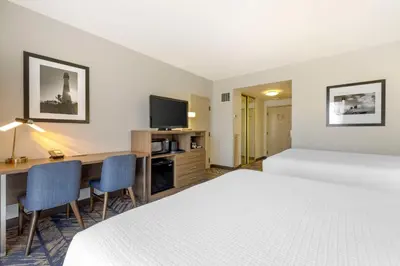 a hotel room with two beds and a desk and a tv at Best Western Plus Bayside Inn in San Diego