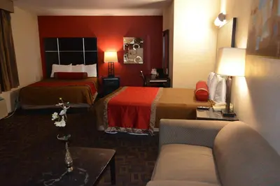 a hotel room with two beds and a couch at Harbor Inn & Suites Oceanside in Oceanside