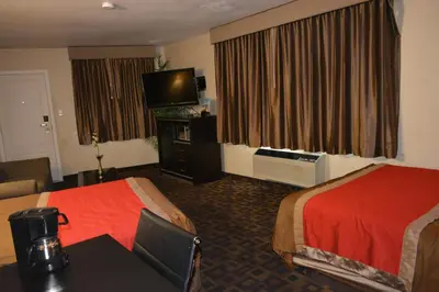 a hotel room with two beds and a flat screen tv at Harbor Inn & Suites Oceanside in Oceanside
