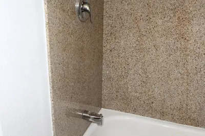 a shower in a bathroom with a tile wall at Harbor Inn & Suites Oceanside in Oceanside