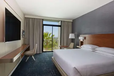 a hotel room with a large bed and a television at Hyatt Regency Newport Beach West in Newport Beach