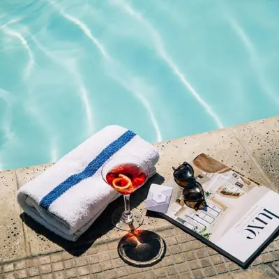 a towel and a glass of wine next to a pool at Hyatt Regency Newport Beach West in Newport Beach