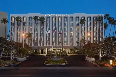 a large building with palm trees in front of it at Hyatt Regency Newport Beach West in Newport Beach
