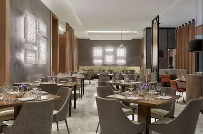 a dining room with tables and chairs and a restaurant at Hyatt Regency Newport Beach West in Newport Beach