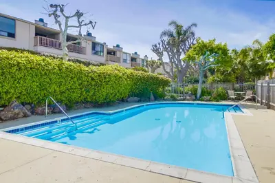 a swimming pool in front of a building at Beachfront feat Private Den SS166 in Solana Beach