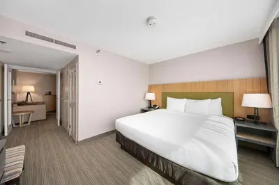 a hotel room with a large bed and a bedroom at Country Inn & Suites by Radisson, San Diego North, CA in Mira Mesa