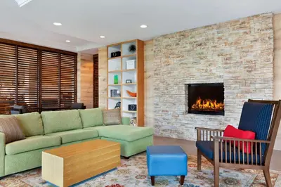 a living room with a couch and a fireplace at Country Inn & Suites by Radisson, San Diego North, CA in Mira Mesa