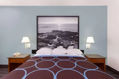 a bedroom with a bed with a large picture on the wall at Super 8 by Wyndham El Cajon San Diego in El Cajon