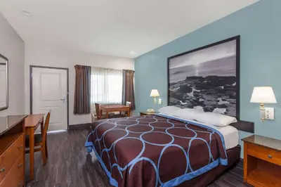 a hotel room with a large bed and a desk at Super 8 by Wyndham El Cajon San Diego in El Cajon