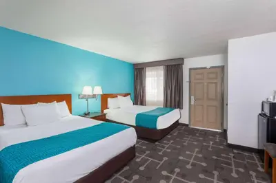 a hotel room with two beds and a television at Howard Johnson by Wyndham National City/San Diego South in National City