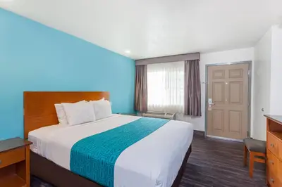 a hotel room with a large bed and a door at Howard Johnson by Wyndham National City/San Diego South in National City
