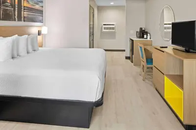 a hotel room with a bed and a tv at Days Inn by Wyndham San Diego-East/El Cajon in El Cajon