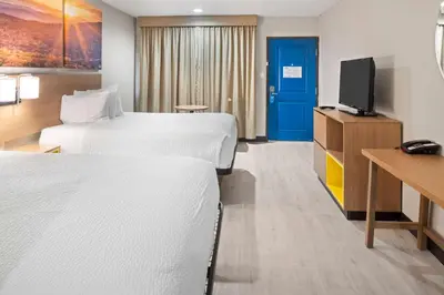 a hotel room with two beds and a tv at Days Inn by Wyndham San Diego-East/El Cajon in El Cajon
