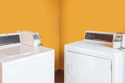 two microwaves sitting on top of a white refrigerator at Days Inn by Wyndham San Diego-East/El Cajon in El Cajon