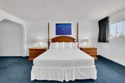 a bedroom with a large white bed and two night stands at Oceanside Marina Suites - A Waterfront Hotel in Oceanside