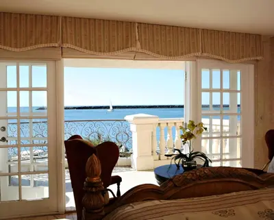 a bedroom with a bed and a view of the ocean at Oceanside Marina Suites - A Waterfront Hotel in Oceanside