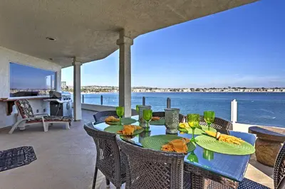 a table on a patio with a view of the water at Beachfront San Diego Condo with Patio on the Bay! in San Diego