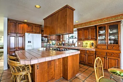 a large kitchen with wooden cabinets and a counter top at Beachfront San Diego Condo with Patio on the Bay! in San Diego