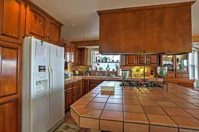 a kitchen with wooden cabinets and a white refrigerator at Beachfront San Diego Condo with Patio on the Bay! in San Diego