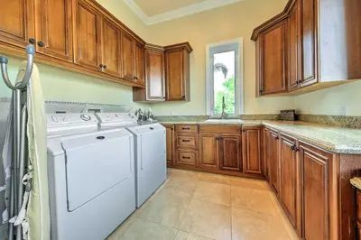 a kitchen with wooden cabinets and a white dishwasher at Luxe Wine Country Estate with Orchard-Facing Balcony in Temecula