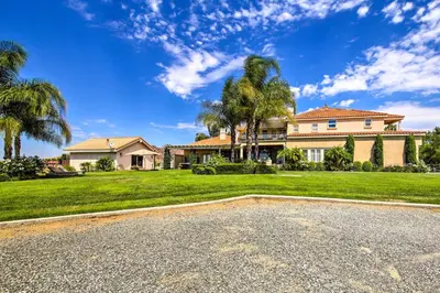 an estate with a large house and palm trees at Luxe Wine Country Estate with Orchard-Facing Balcony in Temecula