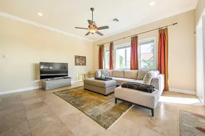 a living room with a couch and a tv at Luxe Wine Country Estate with Orchard-Facing Balcony in Temecula
