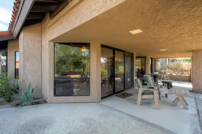 a house with glass doors and chairs on a patio at Country Club Home 2 BR, 2 BA and Den about 1 Mi to Golf in Borrego Springs
