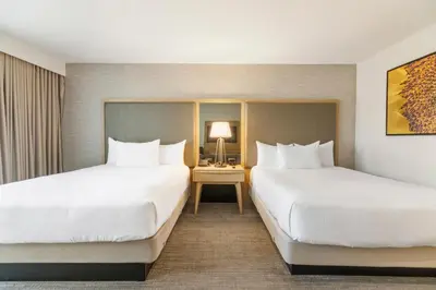 a hotel room with two beds and a table with a lamp at Pala Mesa Resort in Fallbrook