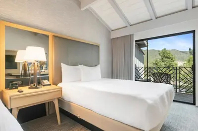 a bedroom with a bed and a balcony at Pala Mesa Resort in Fallbrook