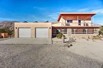 a house with two garage doors in the desert at Borrego Springs Home with Desert and Mountain Views! in Borrego Springs