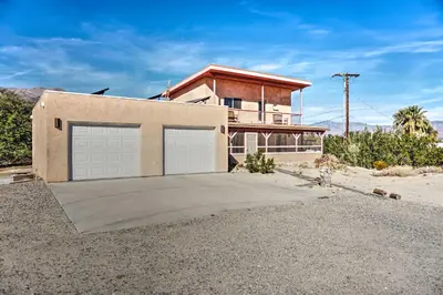 a house with two garage doors in front of it at Borrego Springs Home with Desert and Mountain Views! in Borrego Springs