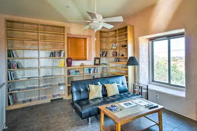 a living room with a leather couch and book shelves at Borrego Springs Home with Desert and Mountain Views! in Borrego Springs