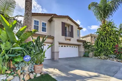 a house with a garage and a palm tree at Luxe San Diego Getaway with Pool and Ocean Views in San Diego
