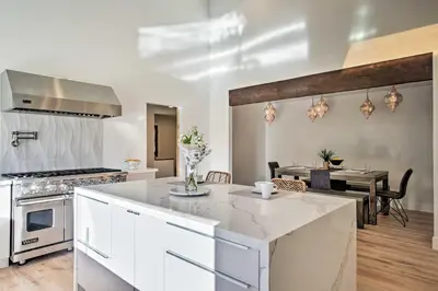 a kitchen with white counters and a dining room with a table at Family Retreat - Private Tennis Court and Game Room in Valley Center