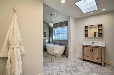 a bathroom with a tub and a sink and a mirror at Family Retreat - Private Tennis Court and Game Room in Valley Center