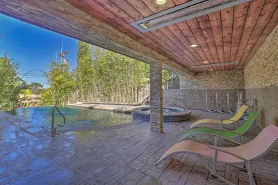 an outdoor patio with chairs and a swimming pool at El Cajon Home with Pool, Grill Station and Decks in El Cajon