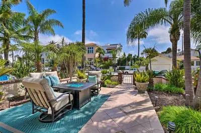 a patio with a table and chairs and palm trees at Oceanside Home with Rooftop Patio, Walk to Beach! in Oceanside