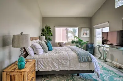 a bedroom with a large bed and a television at Oceanside Home with Rooftop Patio, Walk to Beach! in Oceanside
