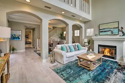 a living room with a white couch and a fireplace at Oceanside Home with Rooftop Patio, Walk to Beach! in Oceanside