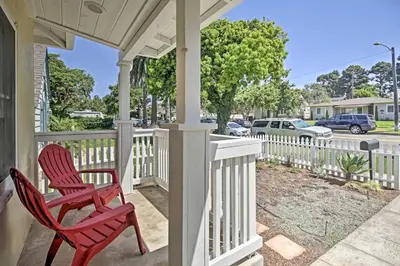 a pair of red chairs sitting on a porch at Oceanside Home with Yard - Walk to Beach and Pier in Oceanside