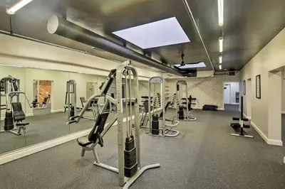 a gym with several treadmills and machines in it at Beachfront Oceanside Condo with Pool and Hot Tub! in Oceanside