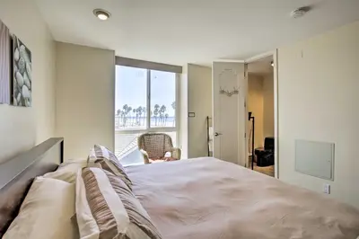 a bedroom with a bed and a large window at Beachfront Oceanside Condo with Pool and Hot Tub! in Oceanside