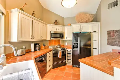 a kitchen with white cabinets and a stainless steel refrigerator at Borrego Springs Condo with Private Hot Tub and Views! in Borrego Springs