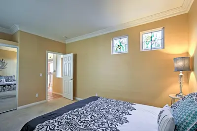 a bedroom with a bed and two windows at Ocean-View San Diego Home with Pool, Patio and Hot Tub in San Diego