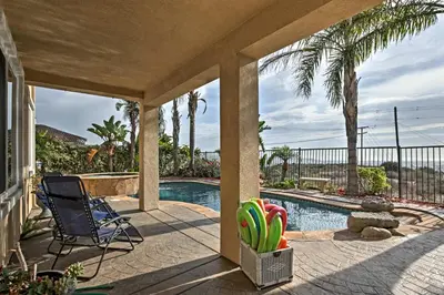 a patio with a chair and a swimming pool at Ocean-View San Diego Home with Pool, Patio and Hot Tub in San Diego