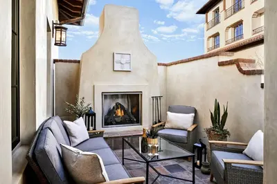 an outdoor patio with chairs and a fireplace at Inn at the Mission San Juan Capistrano, Autograph Collection in San Juan Capistrano