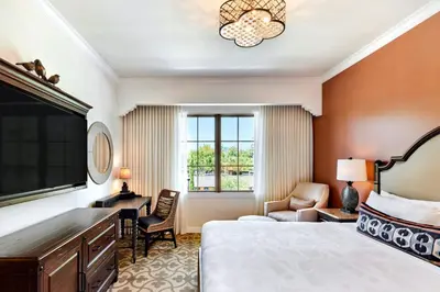 a hotel room with a bed and a desk and a window at Inn at the Mission San Juan Capistrano, Autograph Collection in San Juan Capistrano