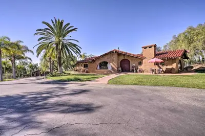 a house with a palm tree in front of a driveway at Equestrian Estate with Horse Stables and Pool! in Valley Center